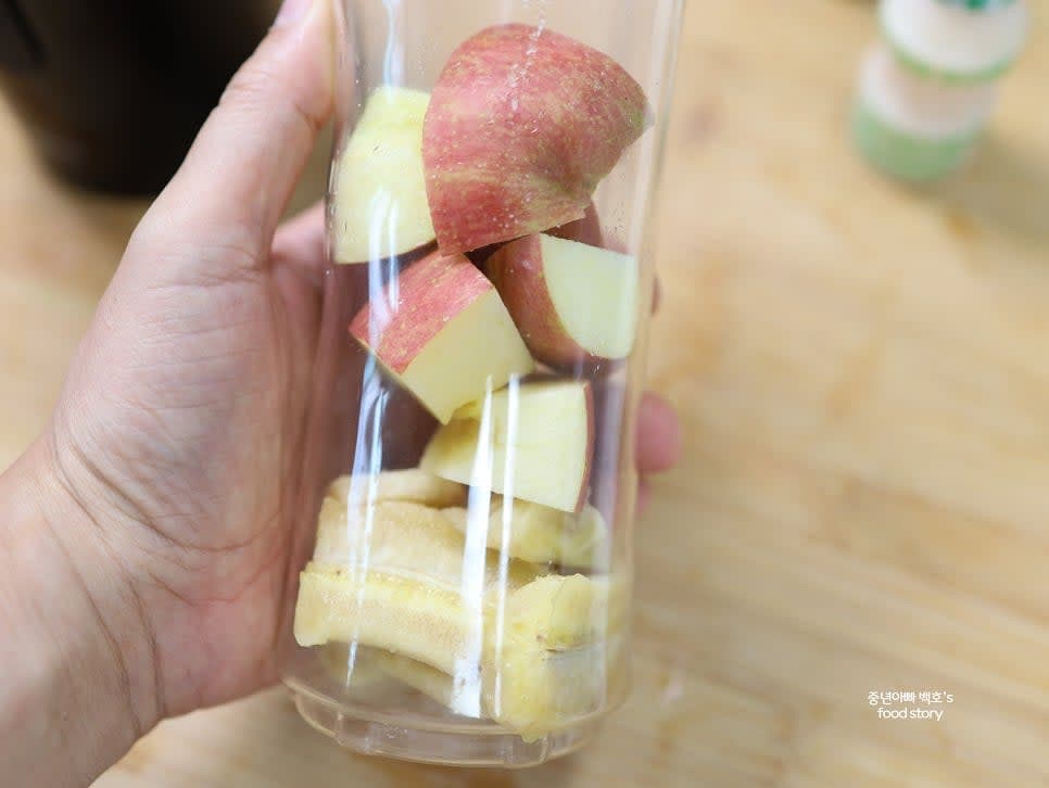 믹서기에 바나나와 사과를 넣습니다.