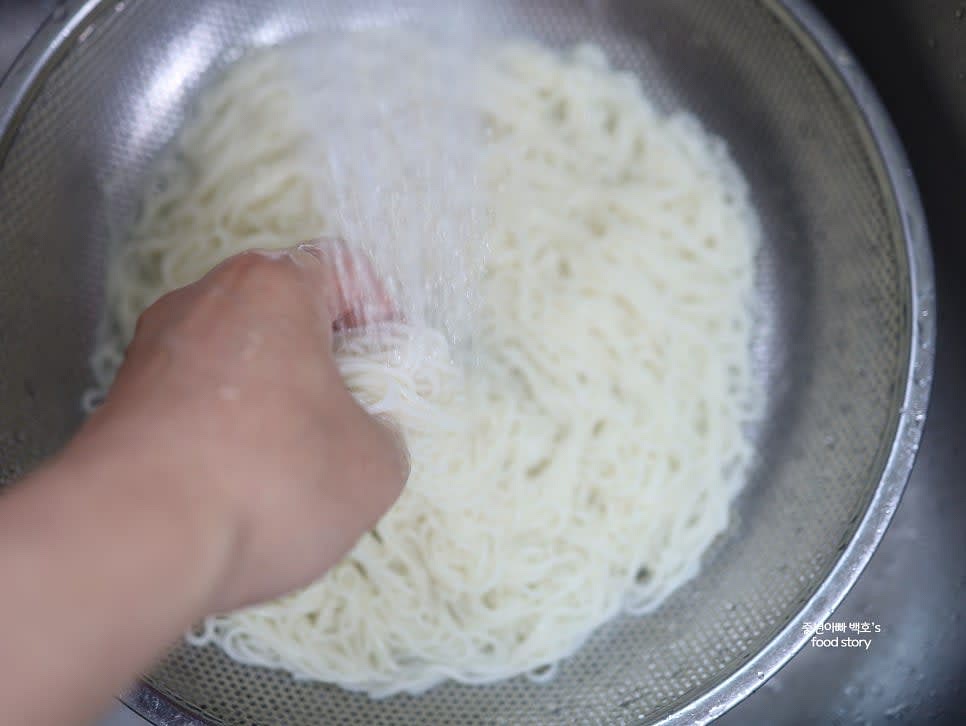 삶은 면을 찬물에 여러 번 헹구어 전분기를 제거하고, 매끄럽게 만들어 채반에 밭쳐 물기를 뺍니다.
