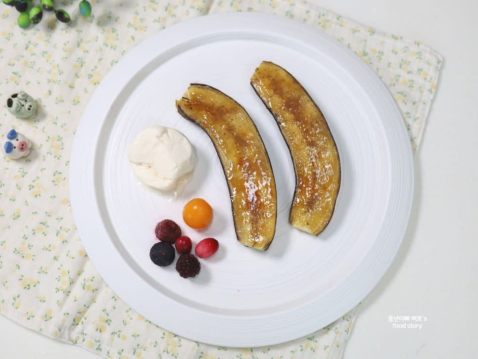 접시에 바나나를 담고 아이스크림, 냉동 베리, 견과류 등 원하는 토핑을 올려 플레이팅합니다.