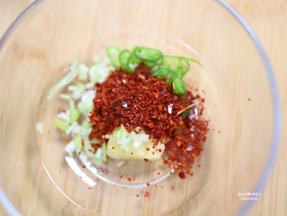 양념그릇에 다진 마늘 1/2스푼, 고춧가루 2스푼, 불닭 소스 3스푼, 썬 대파와 청양고추를 넣어 섞어줍니다.