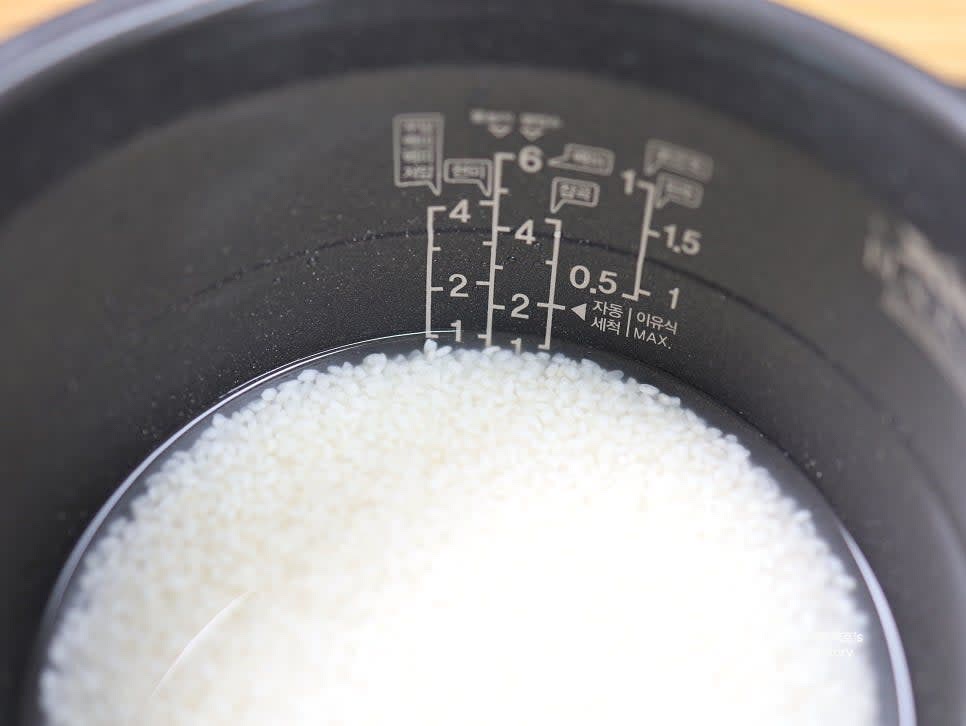 전기밥솥에 불린 쌀을 넣고 물을 평소보다 조금 적게 넣은 뒤, 볶은 가지를 올려 백미 모드로 밥을 짓습니다.