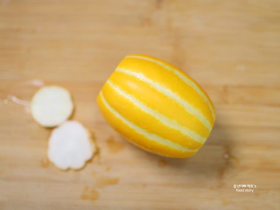 세척한 참외를 물로 헹군 후 물기를 완전히 제거하고 양 끝을 자릅니다.