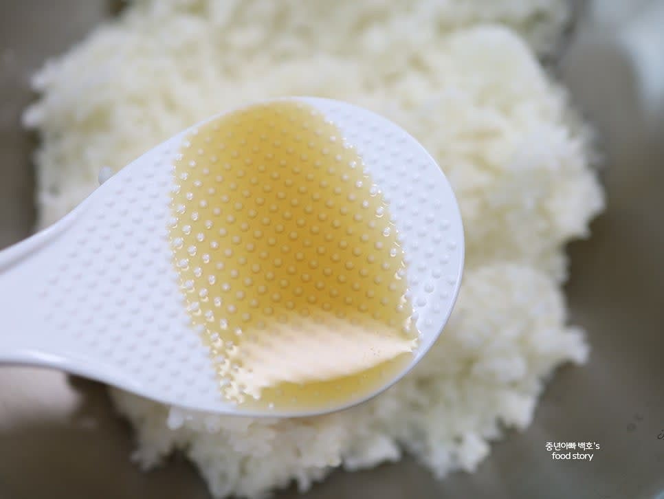 밥 양념을 준비합니다. 고슬고슬하게 지은 밥 5주걱에 참기름 2스푼, 통깨 2스푼, 소금을 약간 넣고 고르게 섞어 줍니다.