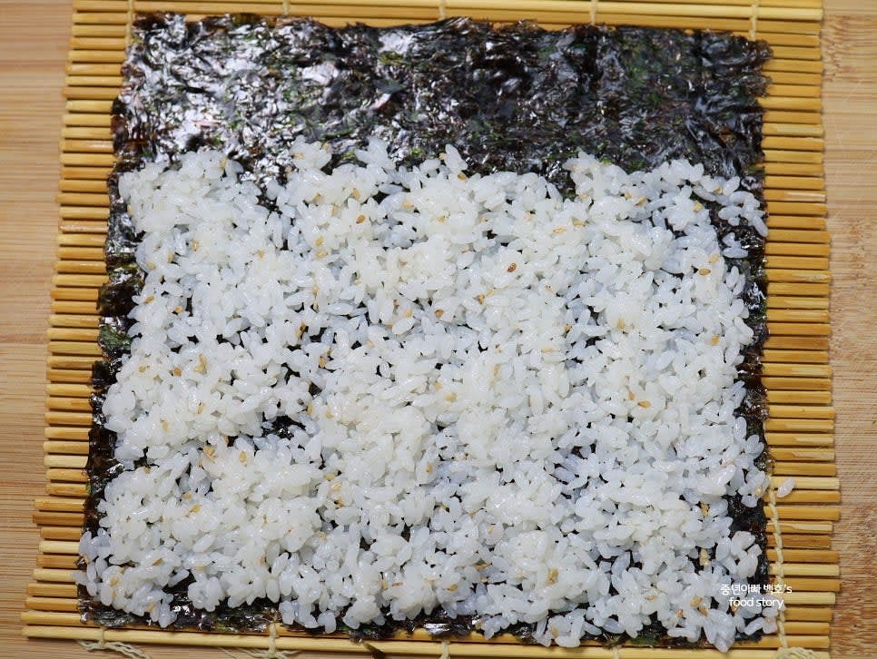 김 한 장을 깔고 밥을 3/4까지 골고루 펴줍니다. 빈 공간이 없도록 고르게 펴주세요.