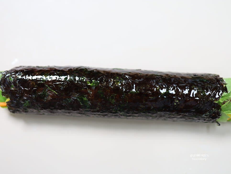 김밥을 단단히 말아줍니다. 참기름을 살짝 발라 마무리한 뒤 적당한 크기로 썰어줍니다.