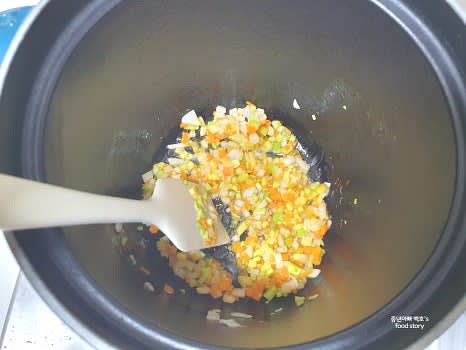 깊은 냄비에 참기름 1스푼을 넣고 약불에서 다진 야채를 볶아줍니다.