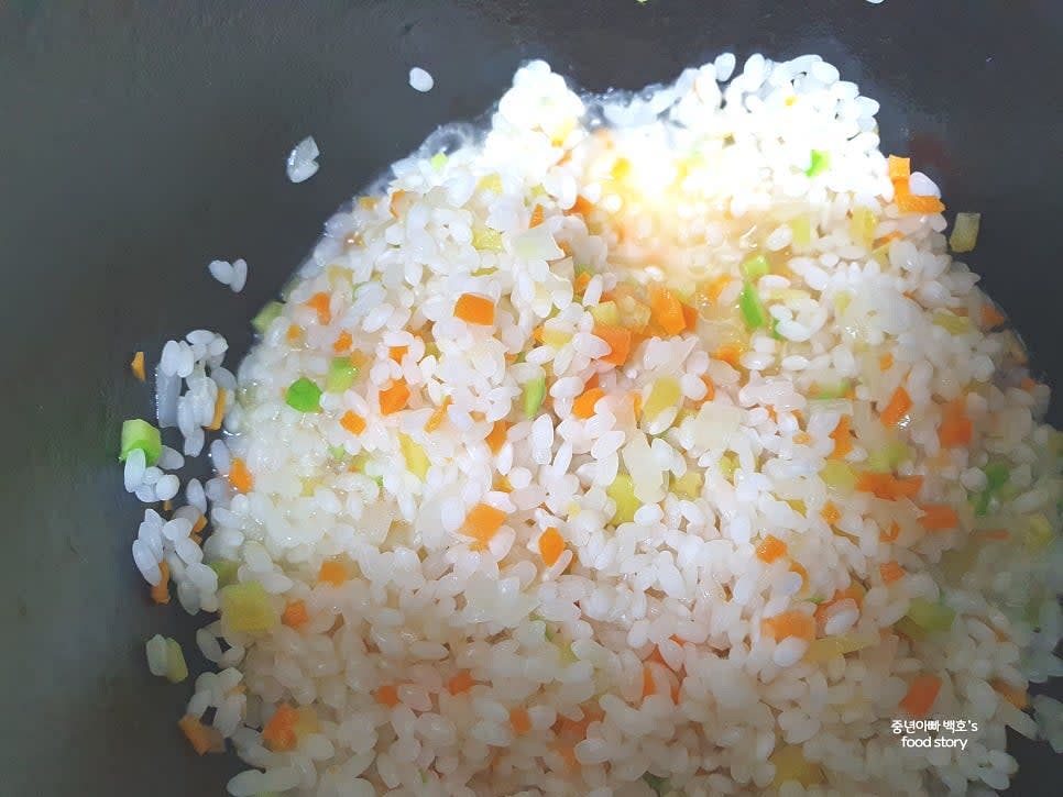 불린 쌀의 물기를 제거한 후 냄비에 넣고 야채와 함께 5분간 볶아줍니다.