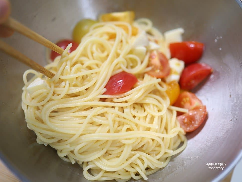 삶아 놓은 스파게티 면을 넣고 모든 재료를 골고루 섞습니다. 간을 보기 위해 면수를 약간 추가합니다.