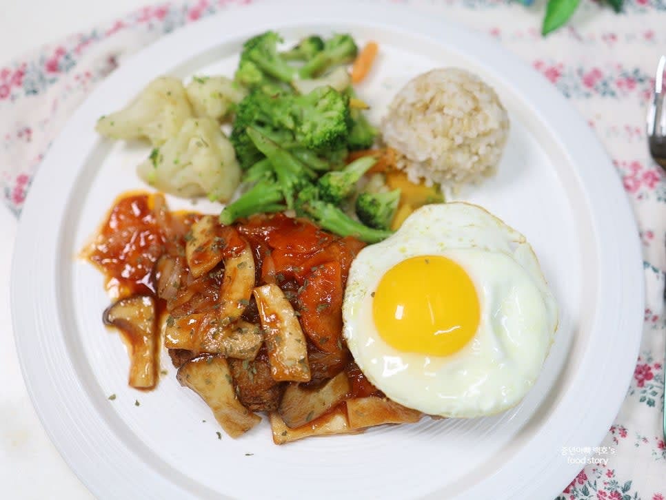 접시에 구운 패티를 놓고 소스를 올립니다. 계란프라이와 가니시를 함께 담아 플레이팅합니다.