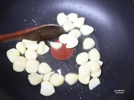 팬에 식용유 3스푼을 두르고 중약 불에서 편으로 썬 마늘을 타지 않게 볶습니다.