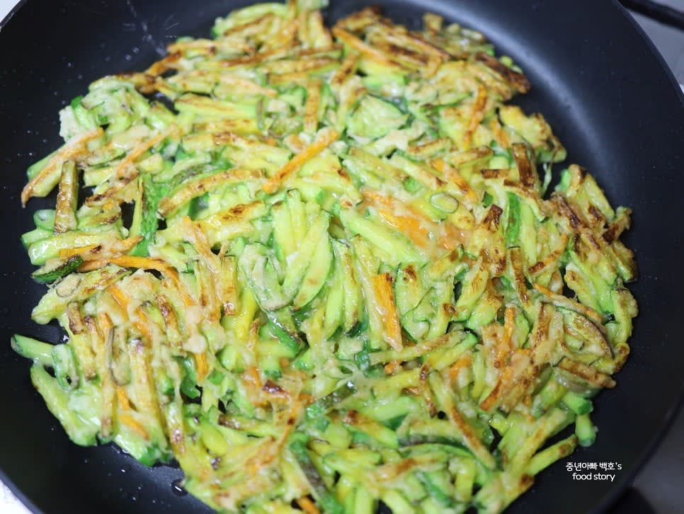 센 불에서 약간 익히다가 불을 중약 불로 낮춰 속까지 고르게 익힙니다. 팬을 흔들어 반죽이 움직이면 뒤집습니다.