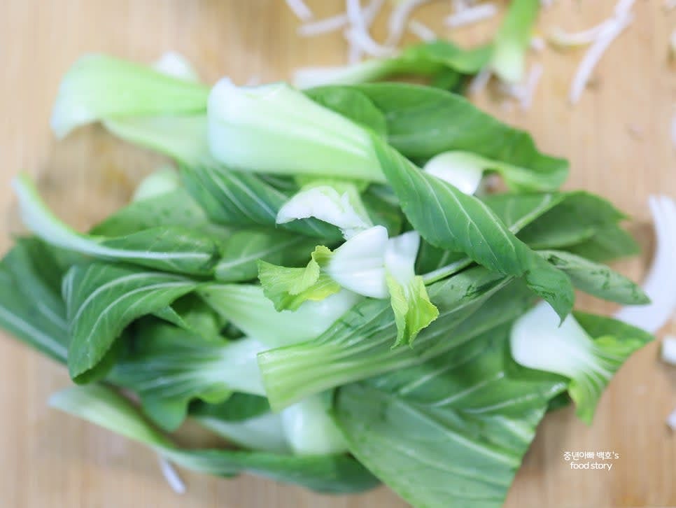 청경채는 큰 잎을 반으로 자르고 깨끗이 씻은 뒤 물기를 제거합니다.