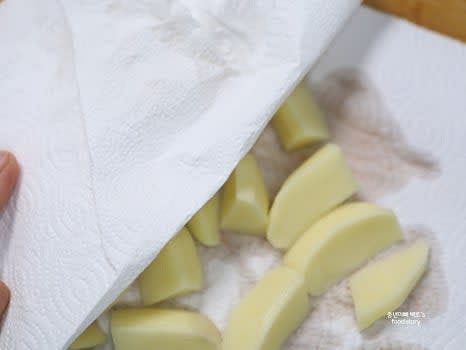 채반에 감자를 밭쳐 물기를 제거한 뒤, 종이타월로 꼼꼼히 닦아줍니다.