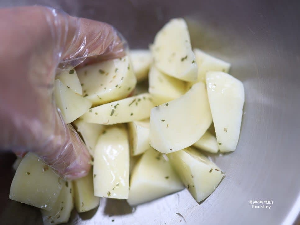 믹싱 볼에 감자를 담고 소금, 올리브오일, 파슬리 가루를 넣어 골고루 섞어줍니다.