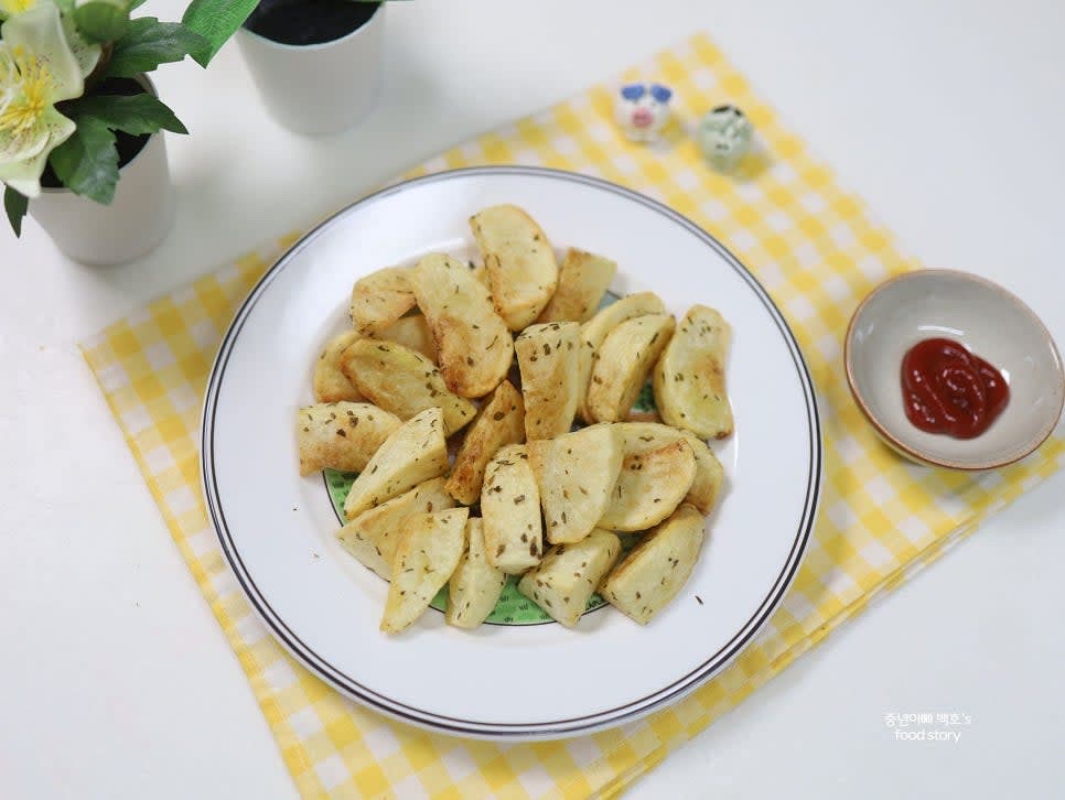 겉이 바삭하게 구워지면 완성된 감자를 그릇에 담고 케첩 소스와 함께 제공합니다.