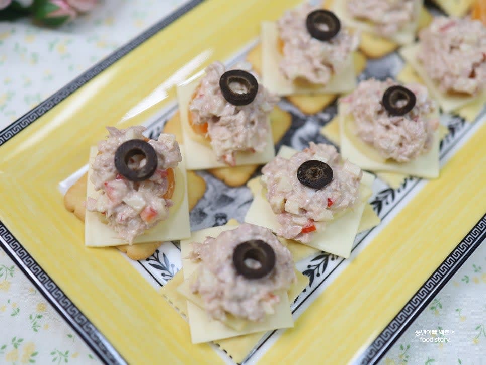 크래커 위에 슬라이스 치즈, 참치마요, 사과, 귤, 블랙 올리브를 차례로 올려줍니다.