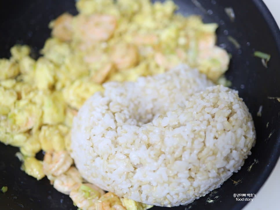 불을 끈 상태에서 밥을 넣고 주걱을 세워 고슬고슬하게 섞어줍니다.