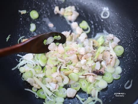 깊은 팬에 식용유를 두르고 대파와 해물을 넣고 중불에서 볶아 향을 냅니다.