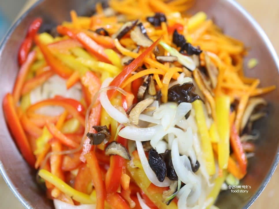 큰 믹싱 볼에 볶아 둔 당면과 콩나물, 채소를 넣고 손으로 골고루 섞습니다.
