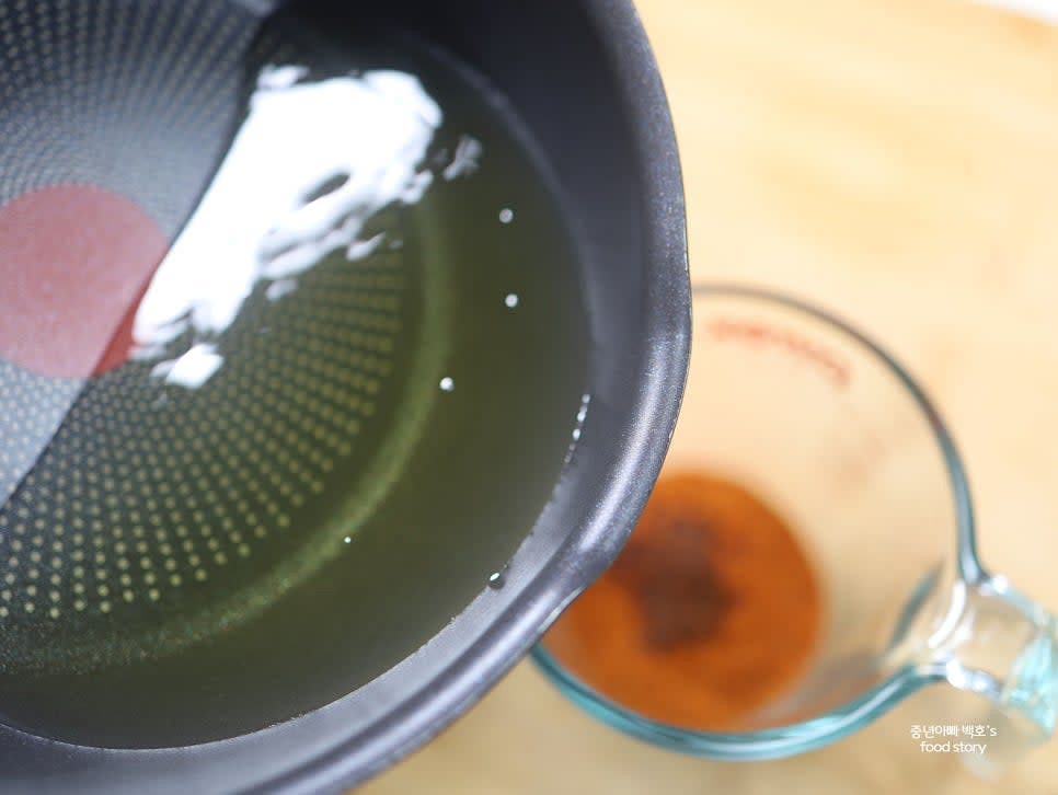 데워진 기름을 고춧가루에 조금씩 부어줍니다. 이때 한두 방울 떨어뜨렸을 때 지지직 소리가 나면 적정 온도입니다.