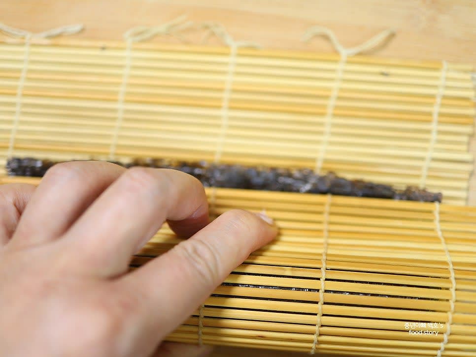 김밥을 공기가 들어가지 않도록 단단히 말아줍니다.