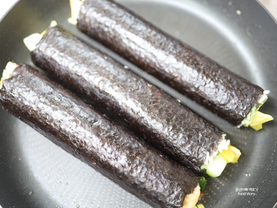 팬에 살짝 구워 김밥 겉면을 더 고소하게 만듭니다.