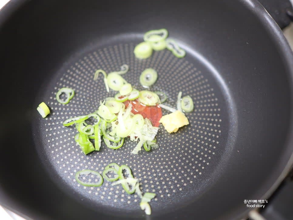 웍에 식용유 1스푼을 두르고 중약 불에서 대파와 다진 마늘 1/4스푼을 넣어 볶습니다.