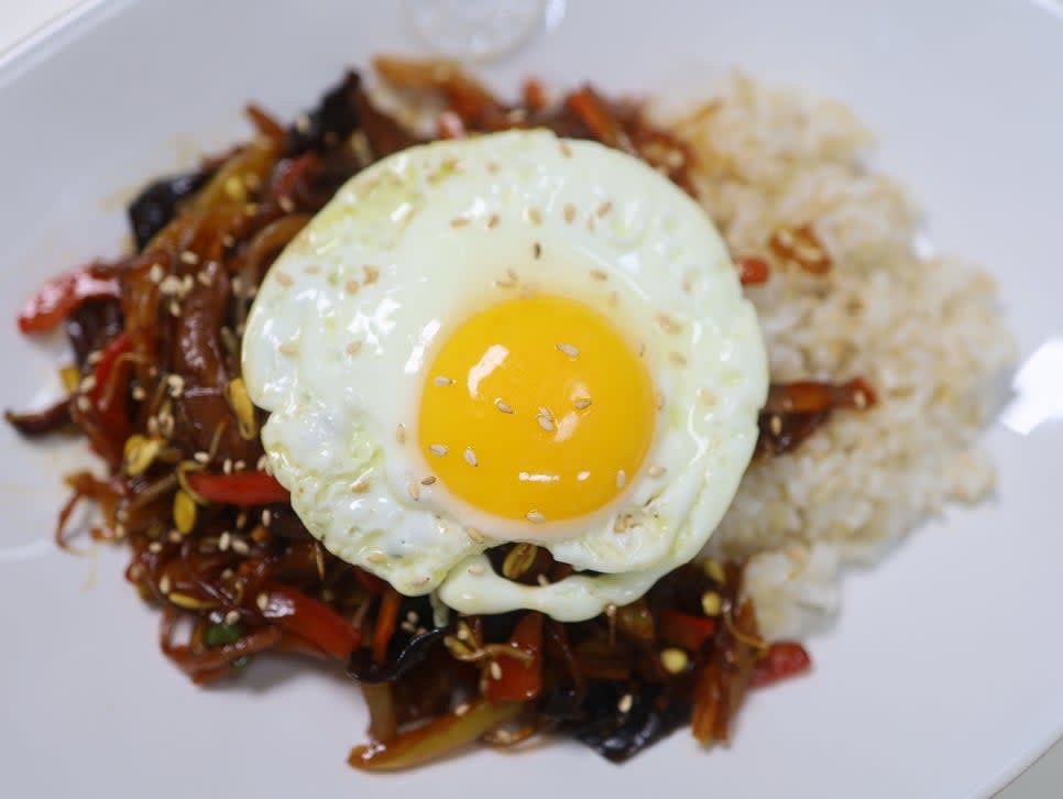 반숙 달걀 프라이를 밥 위에 올리고 통깨를 솔솔 뿌립니다.