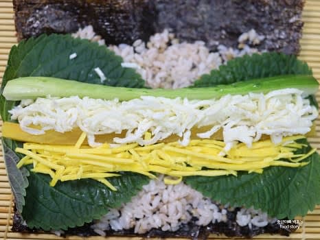 깻잎 위에 단무지, 오이, 계란지단, 데친 브로콜리를 차례로 올려주세요.