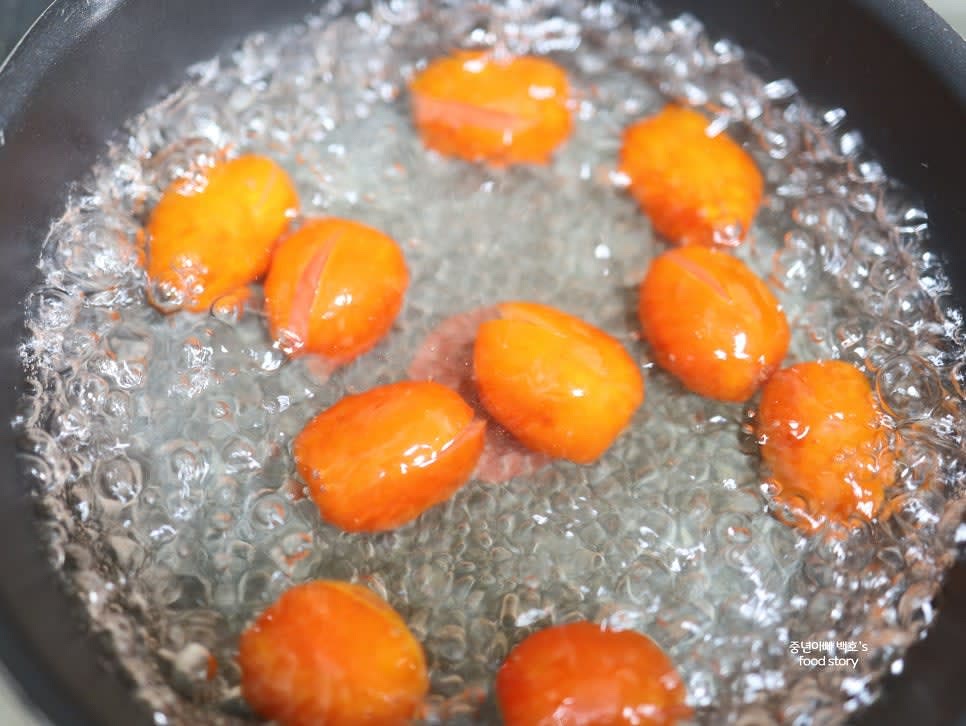 끓는 물에 토마토를 넣고 살짝 데쳐 십자 부분이 벗겨질 때 꺼냅니다.