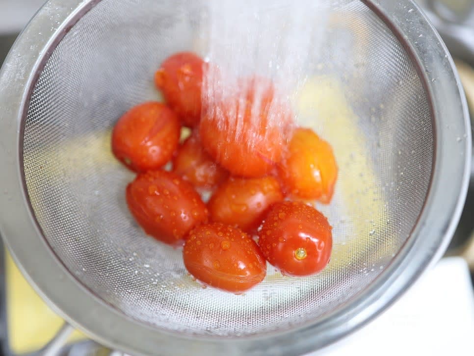 데친 토마토를 찬물에 헹구어 잔열로 익는 것을 멈춘 후 손으로 껍질을 벗깁니다.