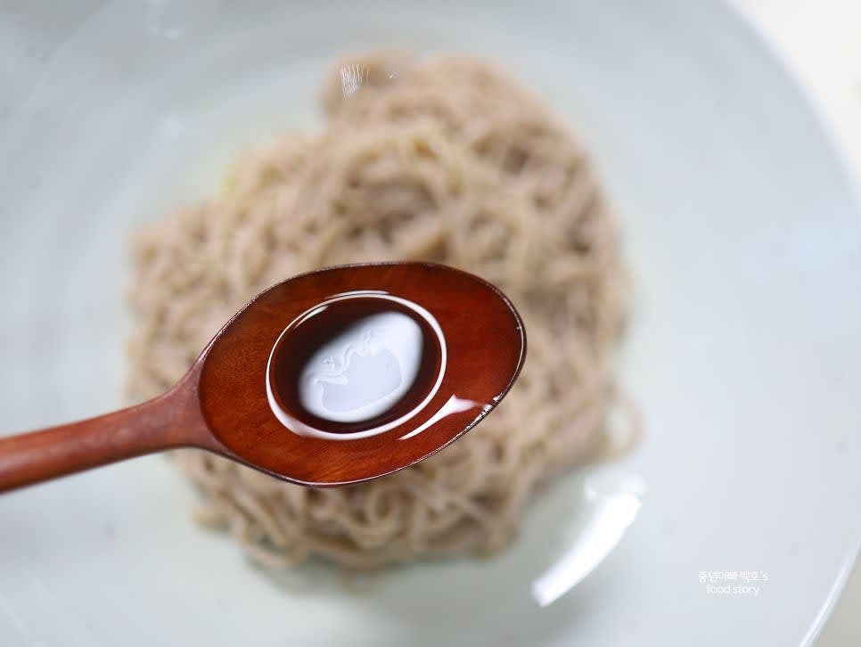 면 위에 들기름 2스푼과 국간장 1/2스푼을 골고루 뿌리고 손으로 조물조물 무쳐줍니다.