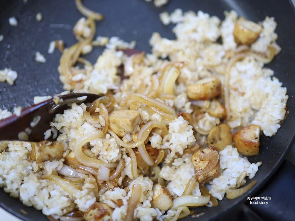 즉석밥을 팬에 넣고 잘 풀어준 뒤 중강 불에서 치킨과 함께 볶습니다.
