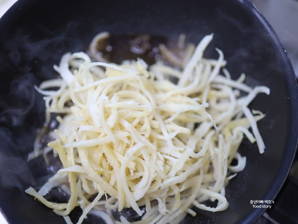 중약 불로 팬을 데워 양념이 끓기 시작하면 손질한 진미채를 넣습니다.