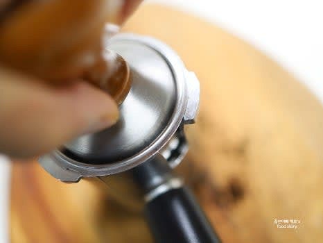 갈아 놓은 커피 가루를 포트에 담아 평평한 곳에 놓고 템퍼로 꾹 눌러 수평을 맞춥니다.