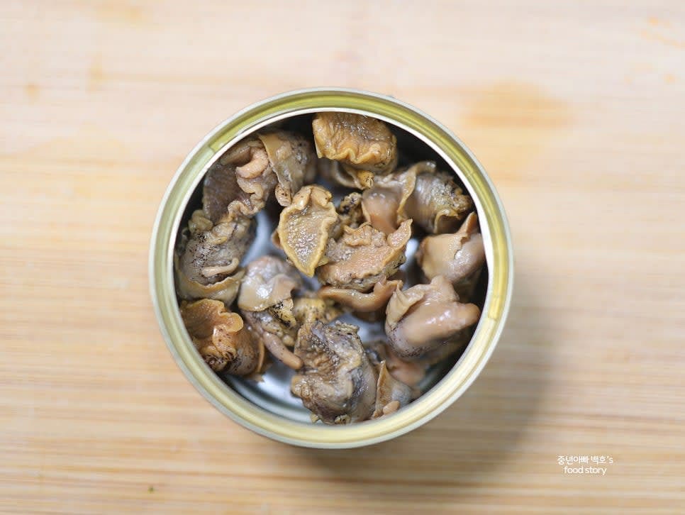 골뱅이 통조림에서 국물을 따라내 다른 그릇에 담고, 골뱅이는 준비해 둡니다.