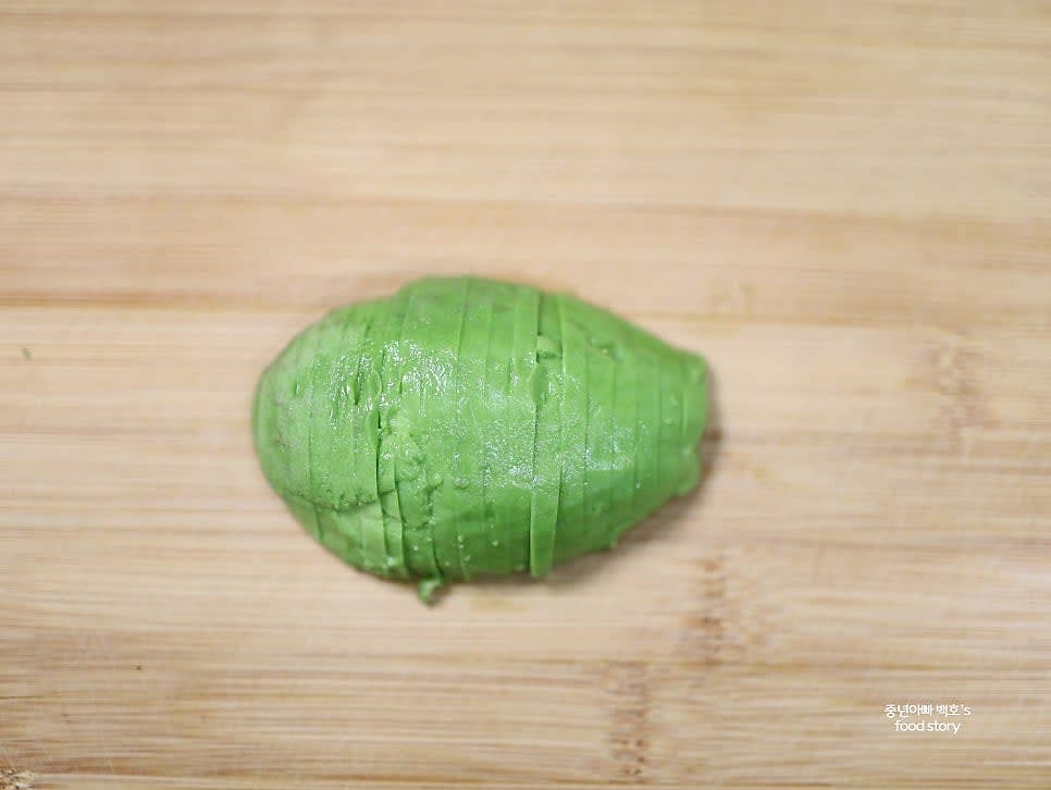 아보카도를 반으로 자르고 씨를 제거한 후, 얇게 썰어주세요.