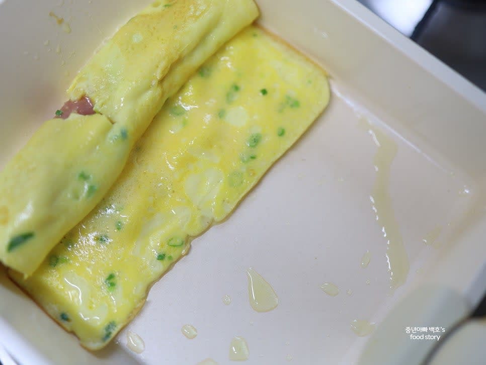 말아진 계란을 팬 경사진 부분으로 이동시키고, 이어지는 부분에 달걀물을 조금 더 부어 굳힌 후 다시 말아줍니다.