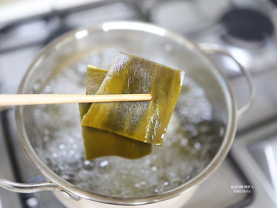 물이 팔팔 끓으면 3분간 더 끓인 뒤 다시마를 건져내고, 동전 육수가 완전히 녹을 때까지 더 끓입니다.