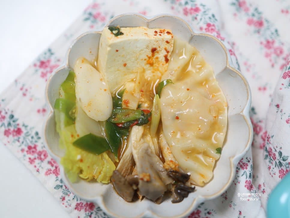 완성된 전골을 그릇에 담아 김가루를 뿌리거나, 취향에 따라 면을 추가해 즐깁니다.