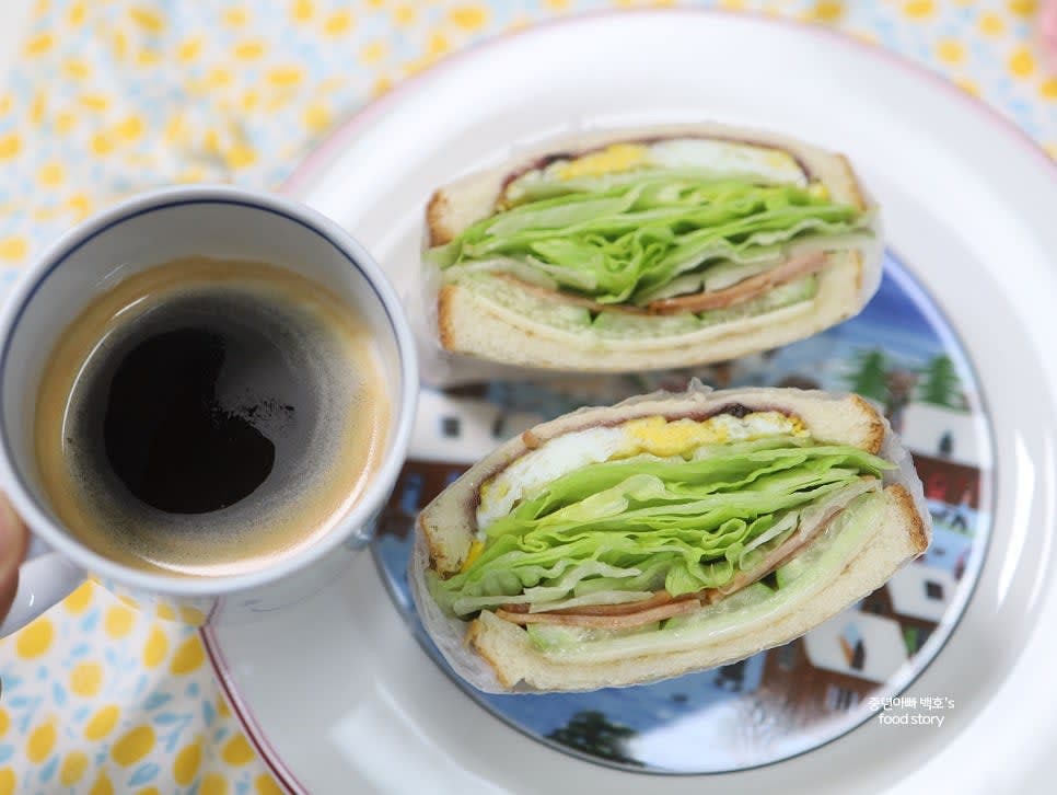 샌드위치를 반으로 잘라 그릇에 담고 아메리카노와 함께 즐깁니다.