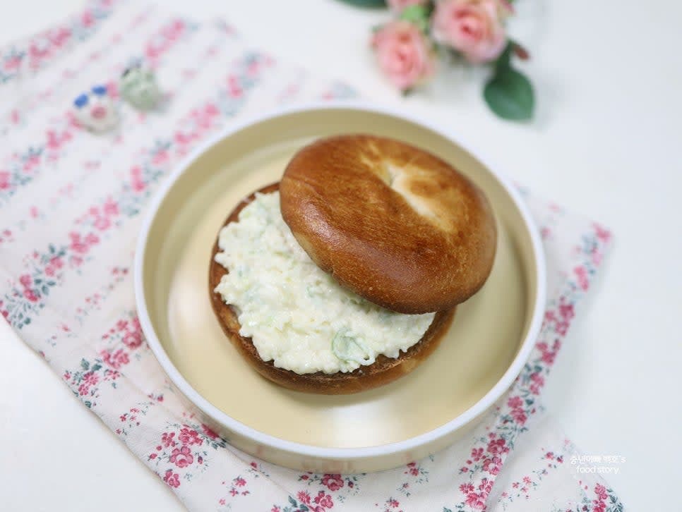 다른 베이글 조각으로 덮어 샌드위치를 완성합니다.