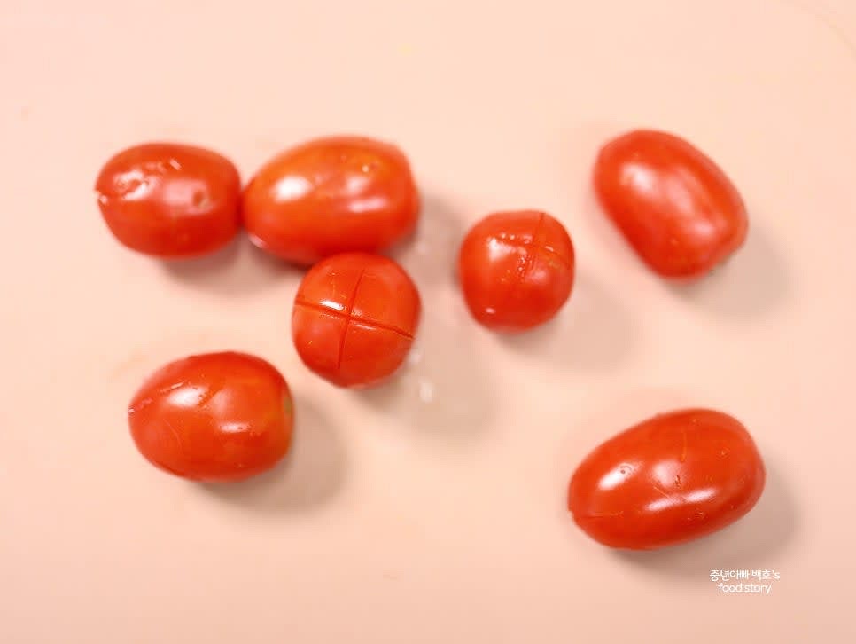 토마토를 깨끗이 씻은 후, 꼭지 반대편에 십자로 칼집을 냅니다.