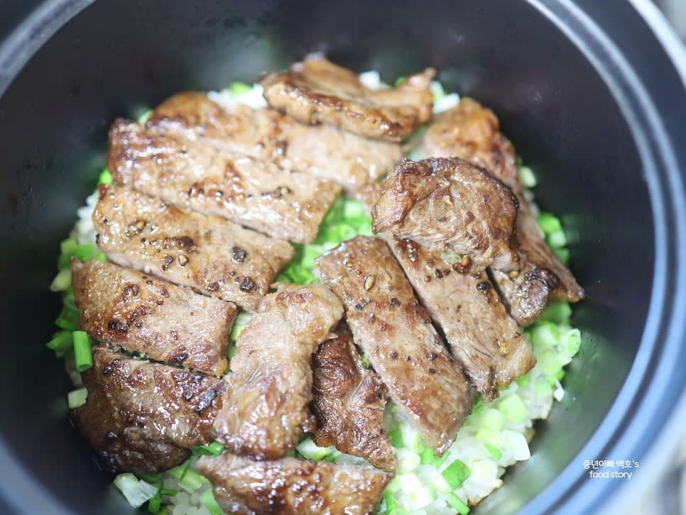 밥이 다 되면 쪽파를 골고루 뿌리고 구운 채끝 스테이크를 잘라 올린 후 뚜껑을 닫고 5분간 뜸을 들입니다.