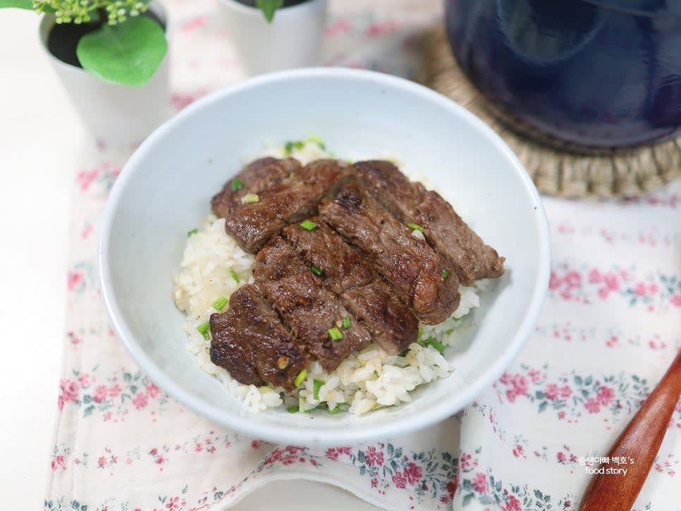 밥과 쪽파를 잘 섞은 후 그릇에 담고, 구운 스테이크를 위에 올려 완성합니다.