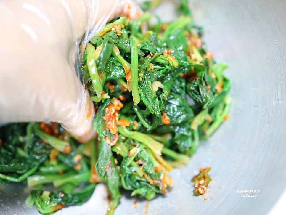 데친 시금치를 믹싱 볼에 넣고 양념장 2/3 정도를 먼저 넣어 조물조물 무칩니다. 필요시 양념을 추가하여 간을 맞춥니다.