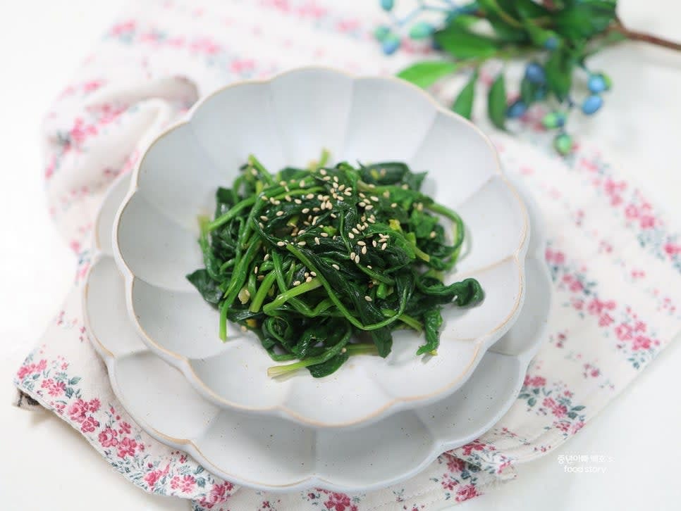 완성된 시금치나물을 그릇에 담고 통깨를 솔솔 뿌려 마무리합니다.