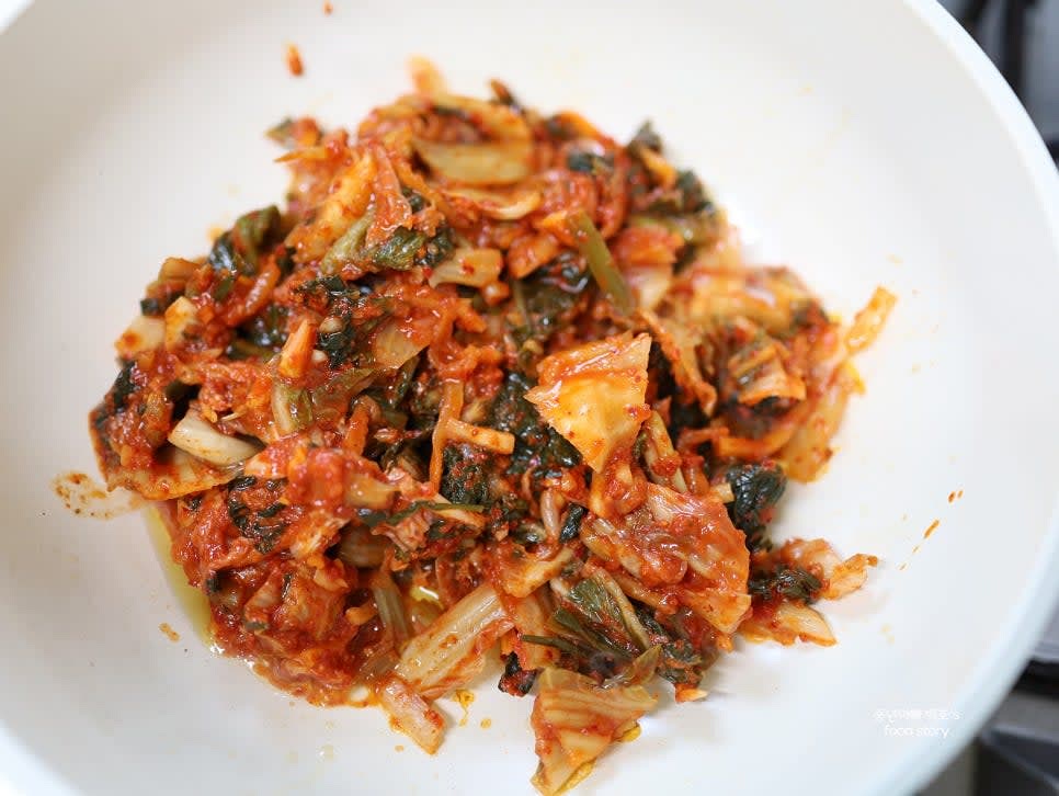 팬에 참기름 3스푼을 두르고, 신 김치를 넣어 숨이 죽을 때까지 충분히 볶습니다.