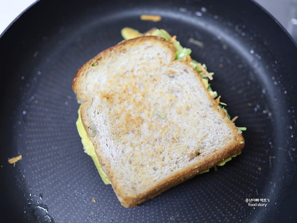 식빵을 반으로 접어 한쪽 면을 더 바삭하게 구워 마무리합니다.
