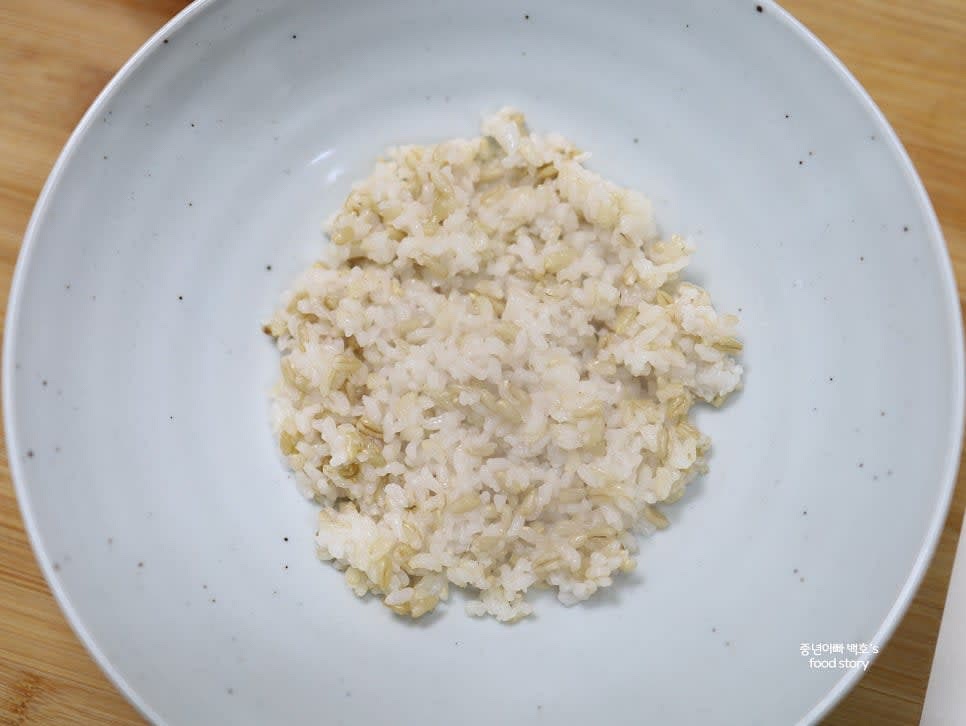 밥 한 공기를 그릇에 담고 참기름 1스푼을 둘러줍니다.